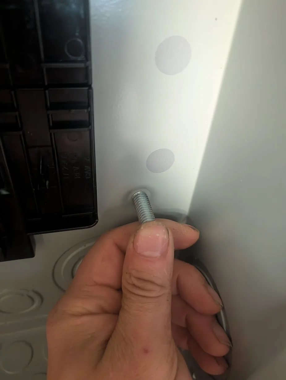 Mounting bolt held next to a factory mounting hole, clearly too large to pass through