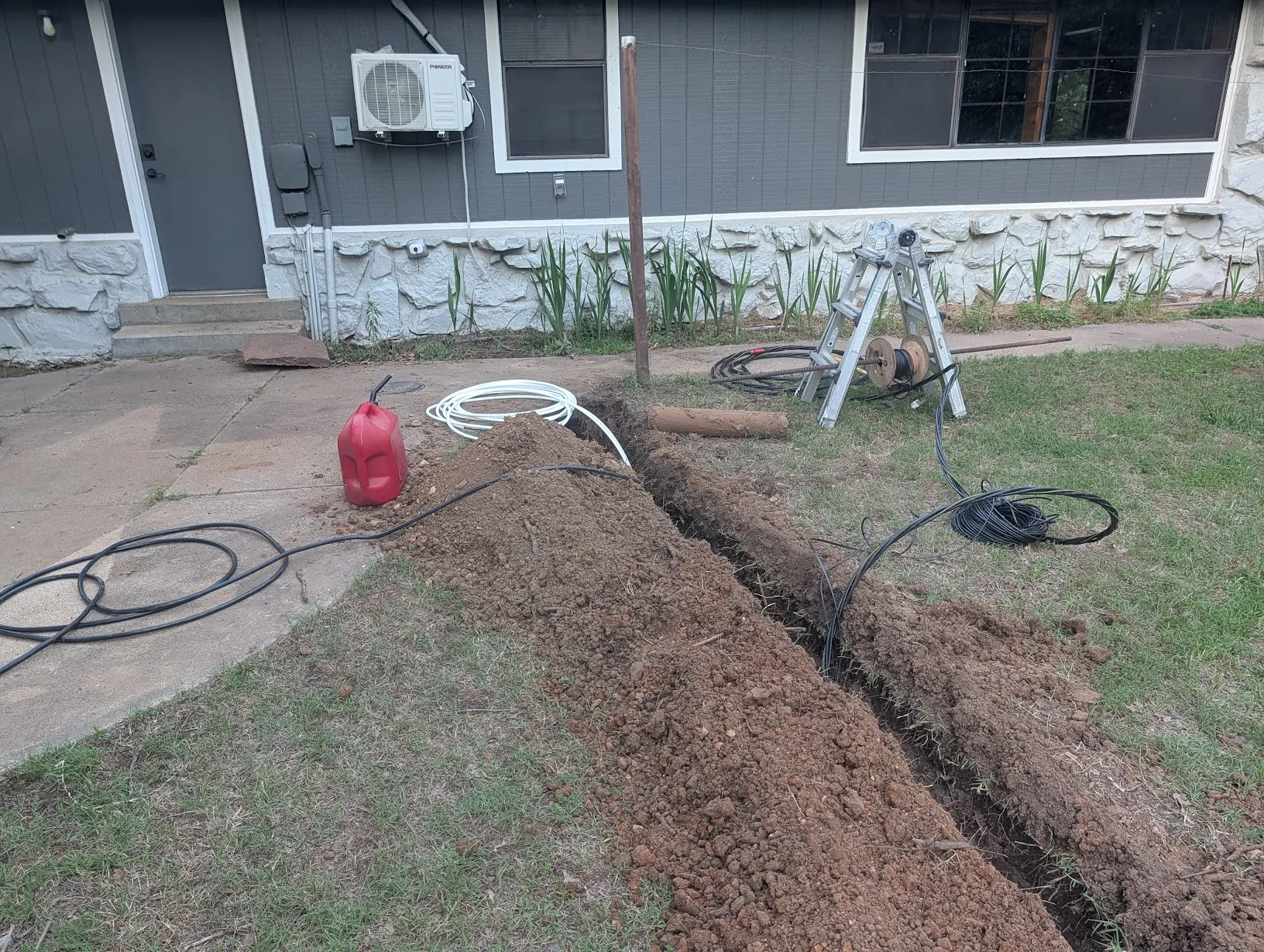 Half-dug sidewalk tunnel with cable partially pulled through