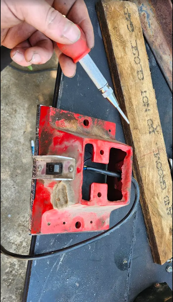 Photo showing center punch, being used to mark the holes