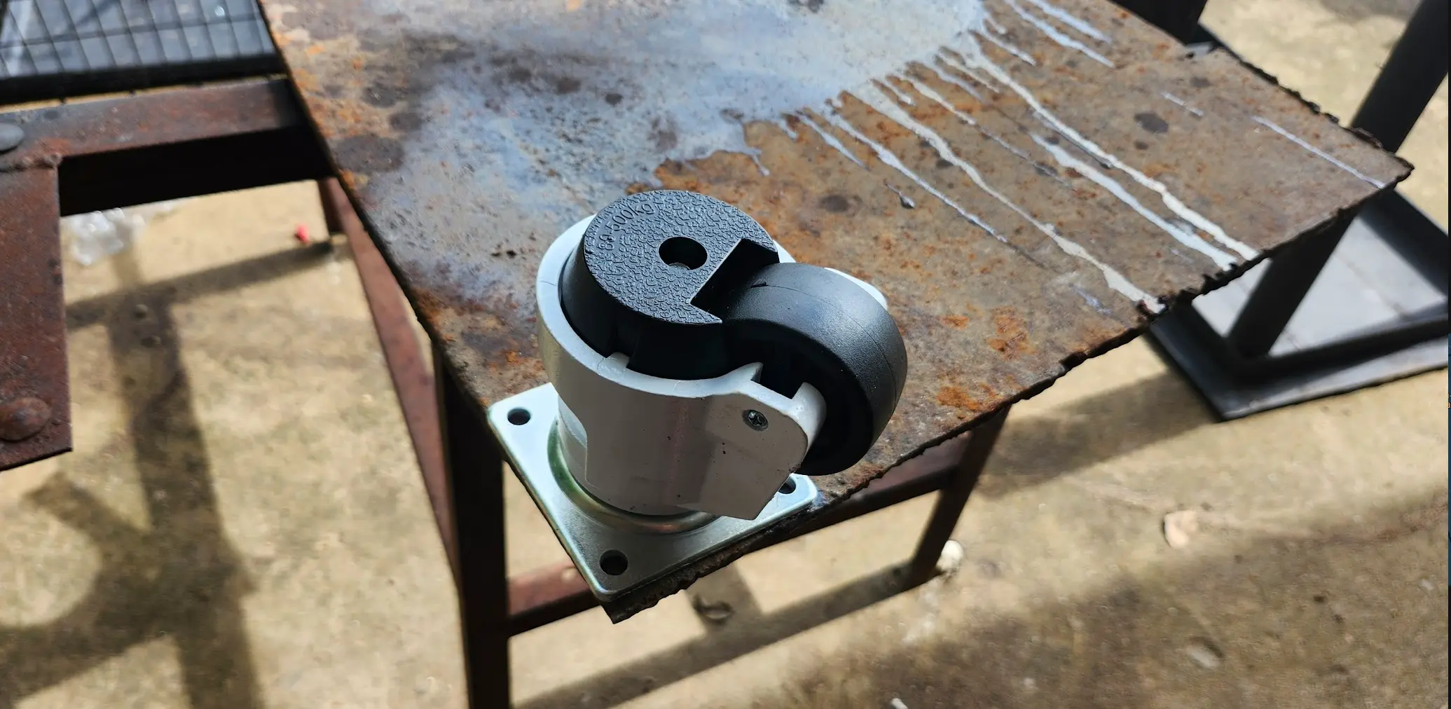 Picture of rusty steel plate, with castor setting on top