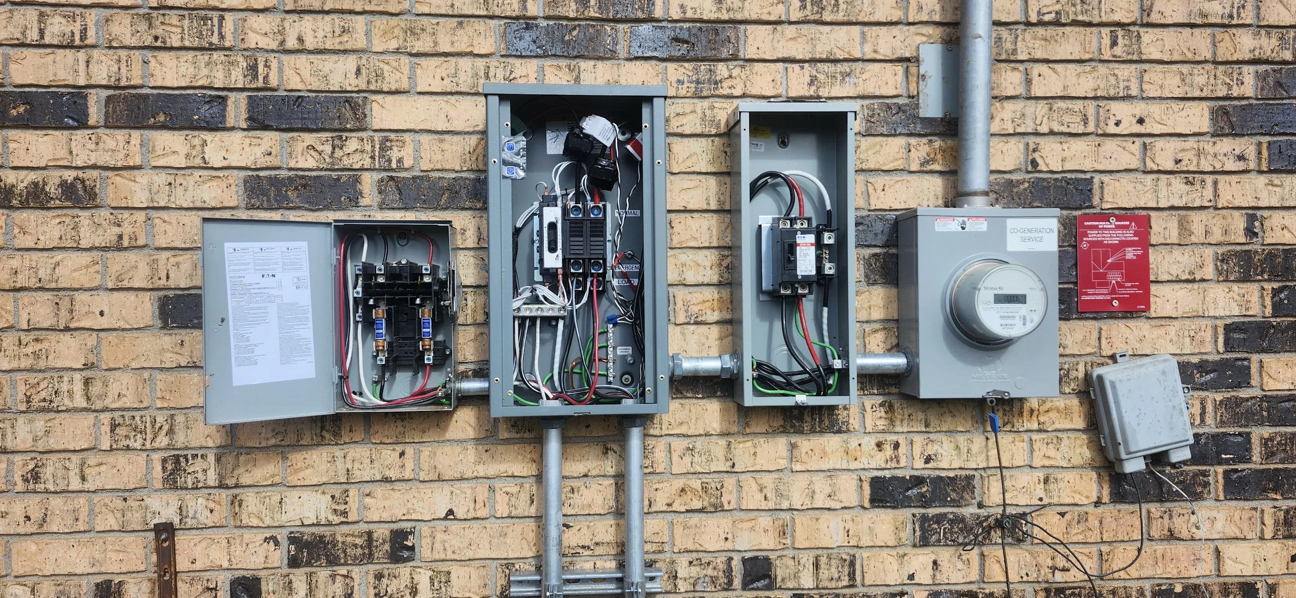 Exterior wall before removal — transfer switch, meter, and disconnect